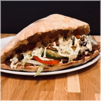 Dubbelgevouwen broodje gevuld met kaas, shoarma, salade en knoflooksaus. Salade bestaat uit: sla, komkommer, tomaat, ui, olijven ,fetakaas en jalapenos